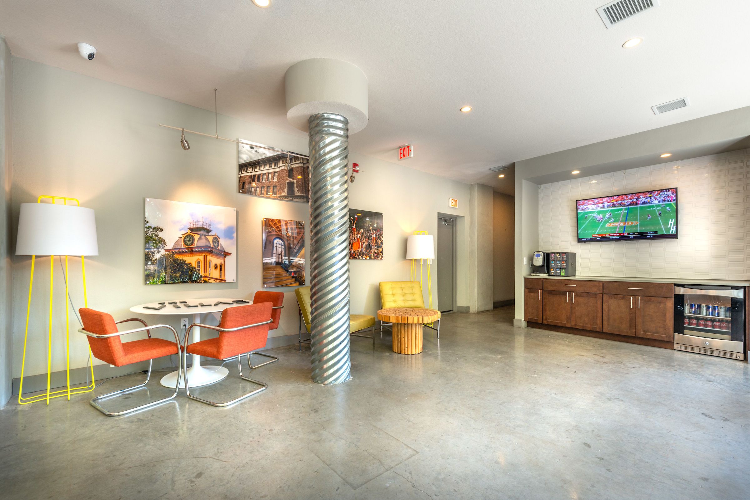 Villas on 26th leasing lobby with modern chairs, desks, and modern artwork on walls, TV screen, coffee machine, and beverage fridge