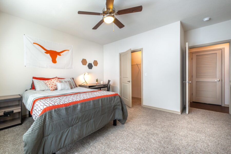 Interior of student apartment bedroom with full bed and walk-in closet